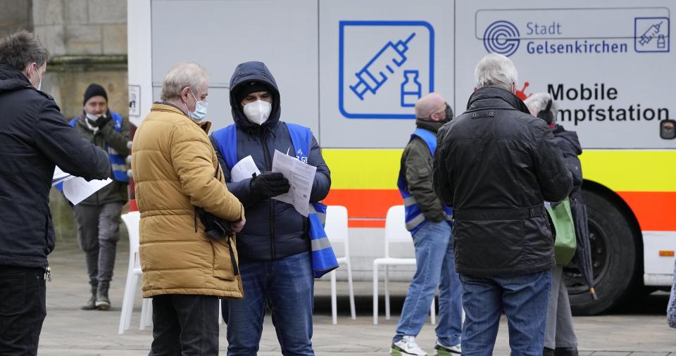 Helpers control documents at a mobile vaccination bus against the coronavirus and the COVID-19 disease in Gelsenkirchen, Germany, Monday, Nov. 29, 2021. (AP Photo/Martin Meissner)