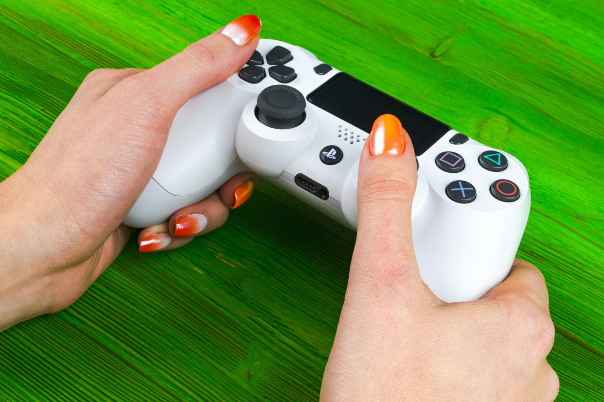 Sankt-Petersburg, Russia, September 24, 2017: Sony PlayStation 4 dualshock game controller in gamers hand on white background studio shot.