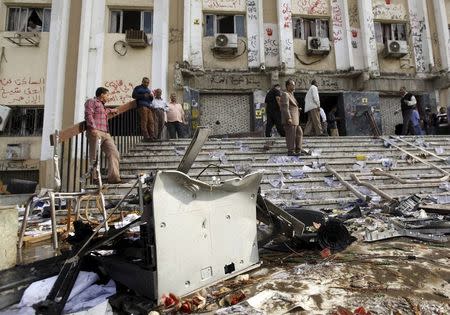 People stand outside the al-Azhar university's administration building which was ruined after clashes broke out during a student protest in Cairo, Egypt in this October 30, 2013 file photo. REUTERS/Mohamed Abd El Ghany/Files