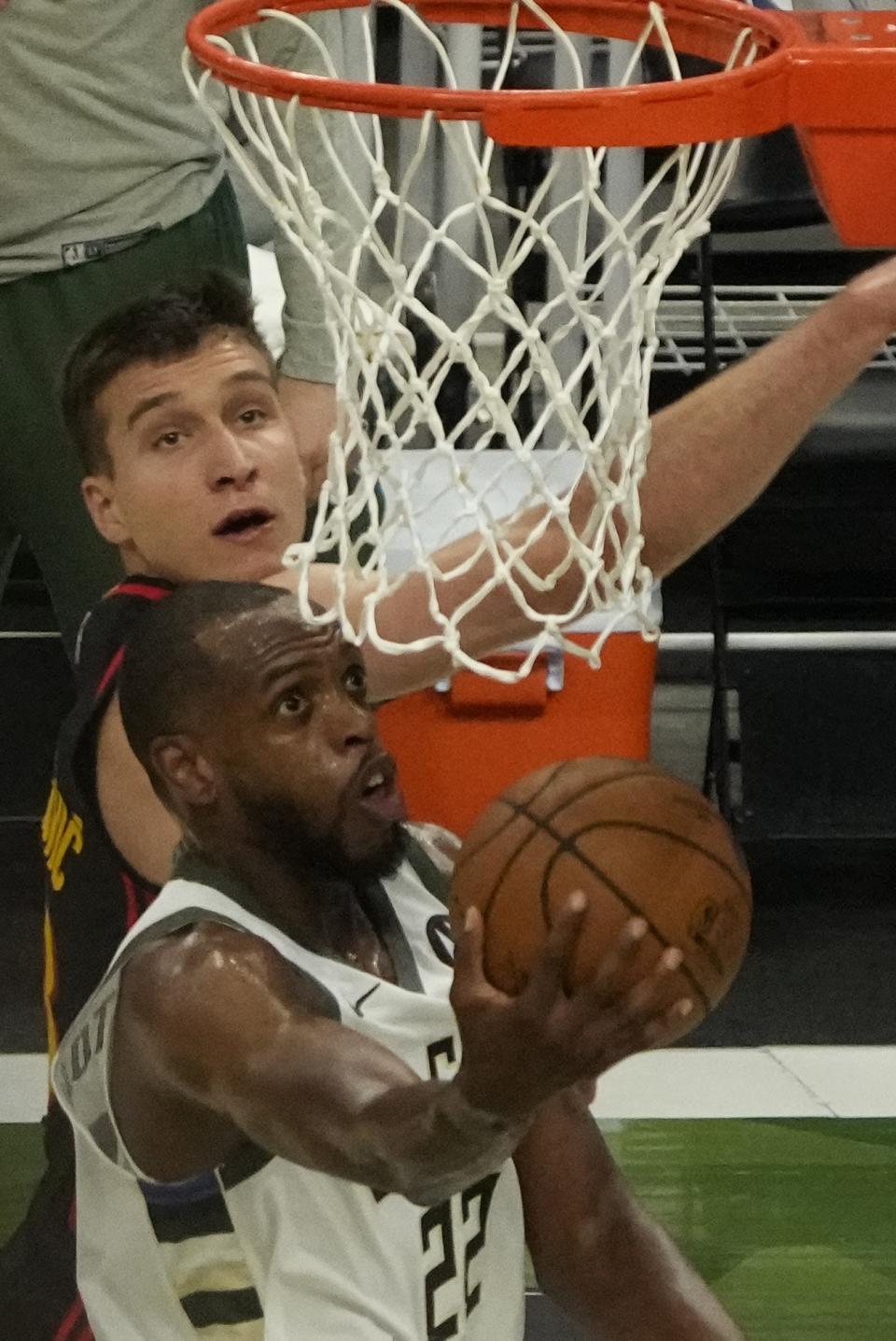 Milwaukee Bucks' Khris Middleton shoots past Atlanta Hawks' Bogdan Bogdanovic during the first half of Game 2 of the NBA Eastern Conference basketball finals game Friday, June 25, 2021, in Milwaukee. (AP Photo/Morry Gash)