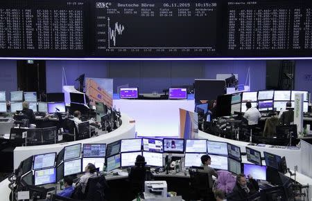 Traders are pictured at their desks in front of the DAX board at the stock exchange in Frankfurt, Germany, November 6, 2015. REUTERS/Staff/remote