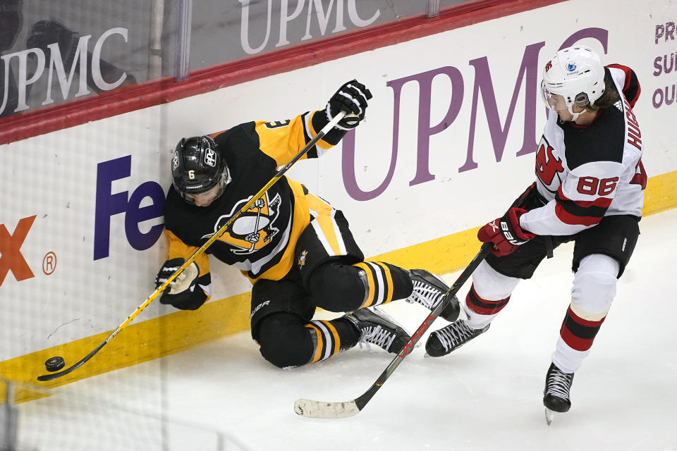 Pittsburgh Penguins' John Marino (6) collides with New Jersey Devils' Jack Hughes during the third period of an NHL hockey game in Pittsburgh, Tuesday, April 20, 2021. (AP Photo/Gene J. Puskar)