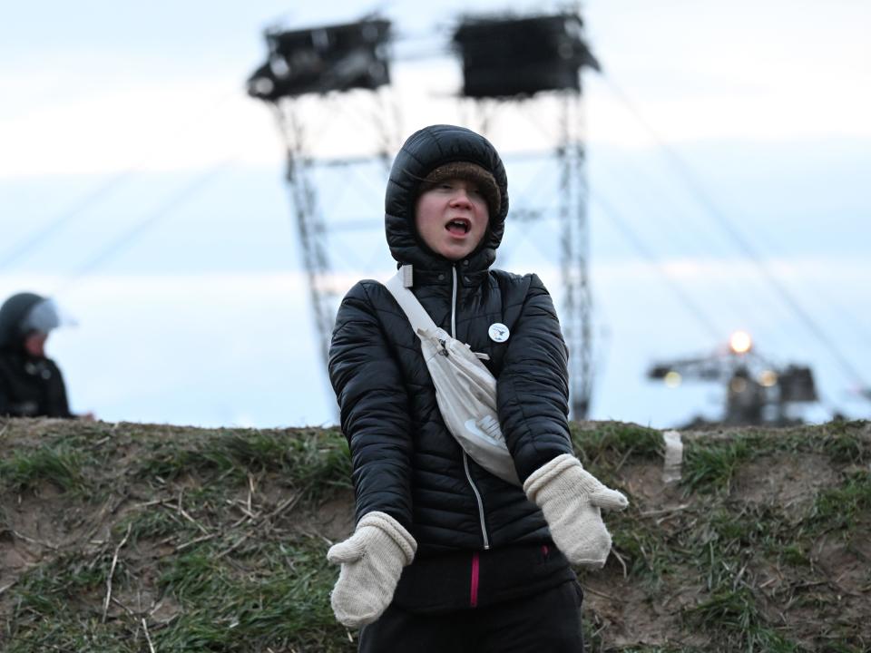 15 January 2023, North Rhine-Westphalia, Erkelenz: Climate activist Greta Thunberg (r) stands between Keyenberg and Lützerath under police guard on the edge of the open pit mine and dances. The energy company RWE wants to excavate the coal lying under Lützerath - for this purpose, the hamlet on the territory of the city of Erkelenz at the opencast lignite mine Garzweiler II is to be demolished. Photo: Federico Gambarini/dpa (Photo by Federico Gambarini/picture alliance via Getty Images)