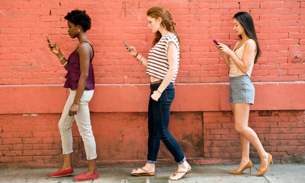 Portrait of three young women using mobile phones