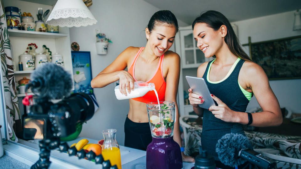 Two women making a smoothie in a vlog.