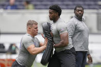 Offensive lineman Jason Godrick, of Nigeria, center, and Offensive lineman Tobias Rodlauer, of Austria, left, take part in the NFL International Combine at the Tottenham Hotspur Stadium in London, Tuesday, Oct. 4, 2022. International athletes on Tuesday are taking part in a series of tests in front of NFL evaluators for a potential position in the NFL's International Player Pathway programme. (AP Photo/Kin Cheung)