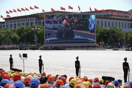 FILE PHOTO: Chinese President Xi Jinping is shown on a big screen at Tiananmen Square as he reviews troops at the beginning of the military parade marking the 70th anniversary of the end of World War Two, in Beijing, China, September 3, 2015 REUTERS/Damir Sagolj/File Photo