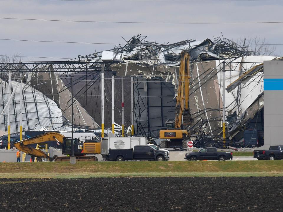 Workers remove debris from an Amazon Fulfillment Center in Edwardsville, Illinois, on December 11, 2021, after it was hit by a tornado (AFP via Getty Images)