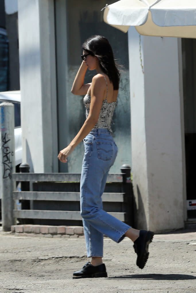 Kendall Jenner wearing a snake-print top, mom jeans and Dr. Martens loafers. - Credit: Mega