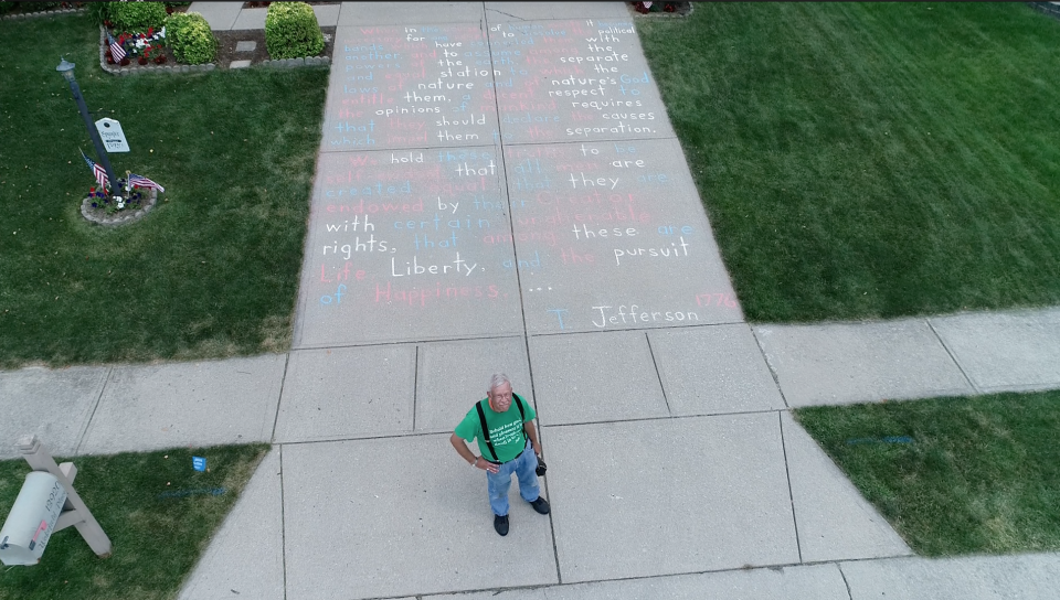 Joe Spangler, 66, stands in front of his artwork: the Declaration of Independence written in chalk on the driveway of his Fishers home.