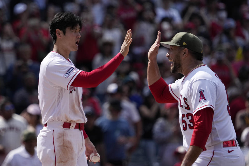 Los Angeles Angels starting pitcher Shohei Ohtani, left, and relief pitcher Carlos Estevez congratulate each other after the Angels defeated the Minnesota Twins 4-2 in a baseball game Sunday, May 21, 2023, in Anaheim, Calif. (AP Photo/Mark J. Terrill)