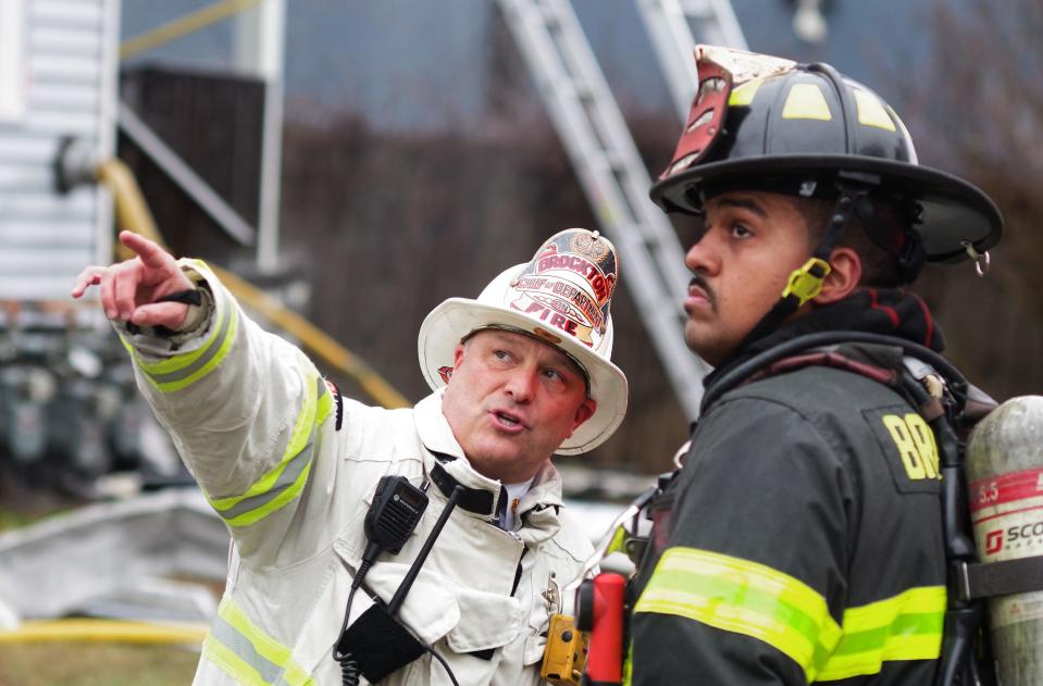 Brockton Fire Chief Brian Nardelli talks with one of his firefighters and points out an area he wants his crew to check for hot spots at a house at 9 Waverly St. where a two-alarm fire took place on Monday, Dec. 11, 2023.