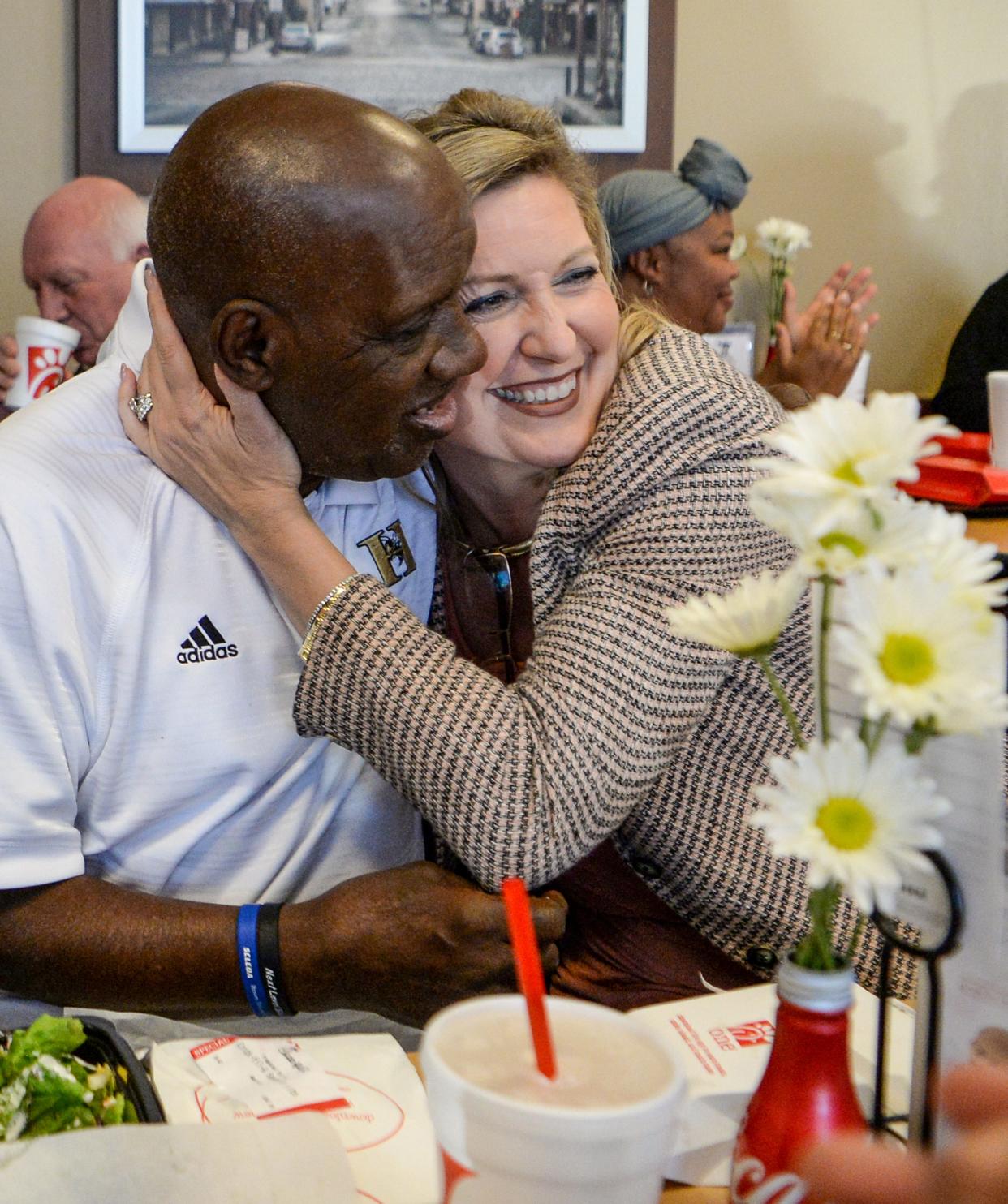 James Robert Radio Kennedy, left, gets a hug from Lisa McWherter, right, as friends join in to celebrate his 71st birthday party at Chick Fil A on Greenville Street in Anderson in 2017.