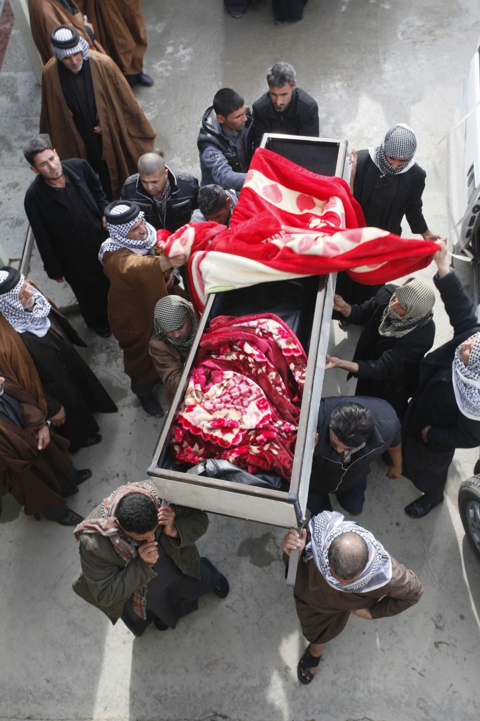 Mourners carry the coffin of a victim killed by a car bomb attack during a funeral in Najaf, 160 km (100 miles) south of Baghdad, January 14, 2014. Four car bombs killed at least 25 people in Shi'ite Muslim districts of Baghdad on Monday, police said, in violence that coincided with a visit to the Iraqi capital by U.N. Secretary-General Ban Ki-moon. The deadliest attack occurred in the mainly Shi'ite neighbourhood of Shaab in eastern Baghdad where a car bomb exploded in a commercial area, killing 11 people and wounding 28. (REUTERS/Alaa Al-Marjani)