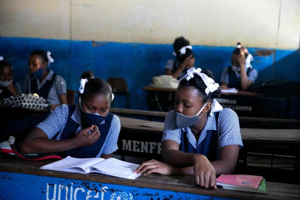 Students read at Lycee Marie Jeanne school while being back to school amid the COVID-19 pandemic in Port-au-Prince, Haiti, on Monday, Aug. 17, 2020. After five months of lockdown, schools are officially reopening, requiring students to wear masks and dividing them into smaller groups with different schedules.