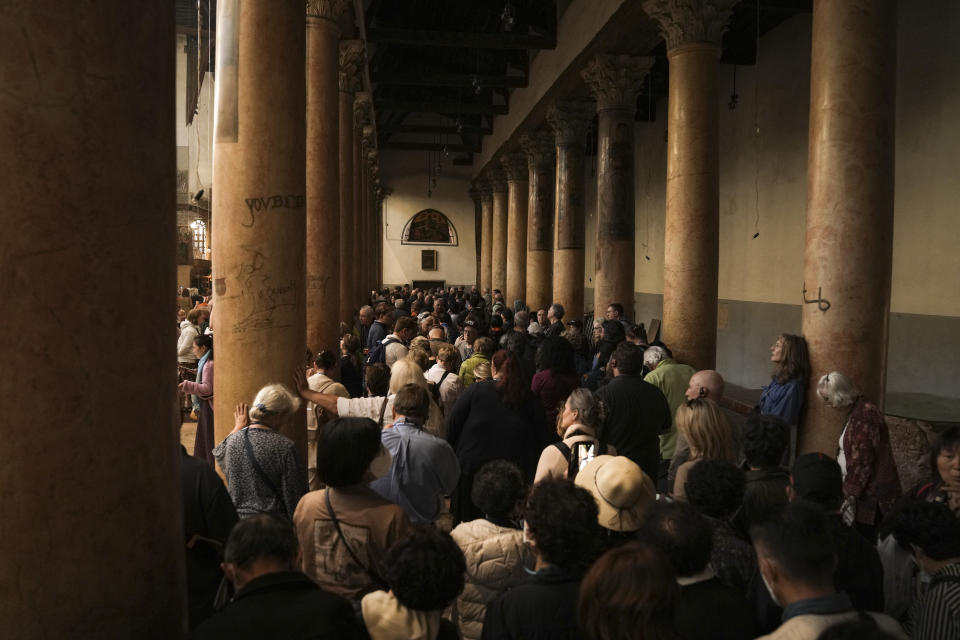 Tourists visit the Church of the Nativity, traditionally believed to be the birthplace of Jesus Christ, in the West Bank town of Bethlehem, Monday, Dec. 5, 2022. Business in Bethlehem is looking up this Christmas as the traditional birthplace of Jesus recovers from a two-year downturn during the coronavirus pandemic. Streets are already bustling with visitors, stores and hotels are fully booked and a recent jump in Israeli-Palestinian fighting appears to be having little effect on the vital tourism industry. (AP Photo/ Mahmoud Illean)
