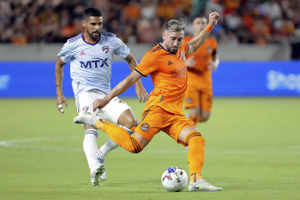 Houston Dynamo midfielder Hector Herrera, right, kicks away the ball in front of FC Dallas forward Franco Jara, left, during the second half of an MLS soccer match Saturday, July 9, 2022, in Houston. (AP Photo/Michael Wyke)