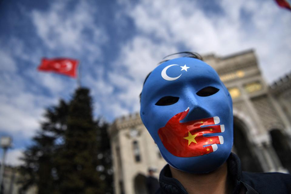 A demonstrator wearing a mask painted with the colors of the flag of East Turkestan takes part in a protest by supporters of the Uyghur minority on Thursday at Beyazid Square in Istanbul, Turkey.