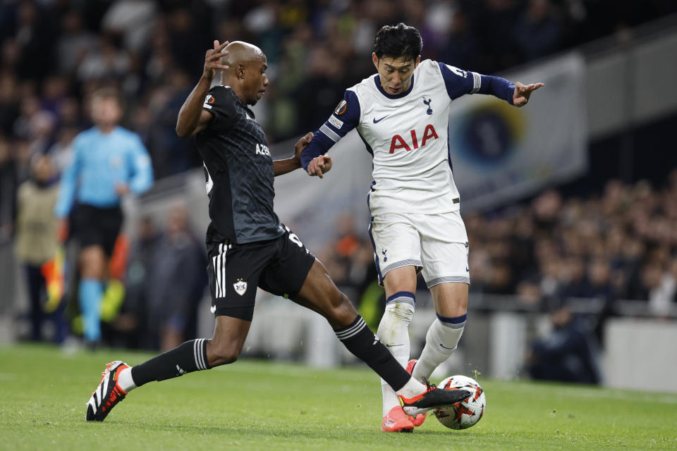 Qarabag's Julio Romao, left, and Tottenham's Son Heung-min fight for the ball during the Europa League soccer match between Tottenham and Qarabag in London, Thursday, Sept. 26, 2024. (AP Photo/David Cliff)