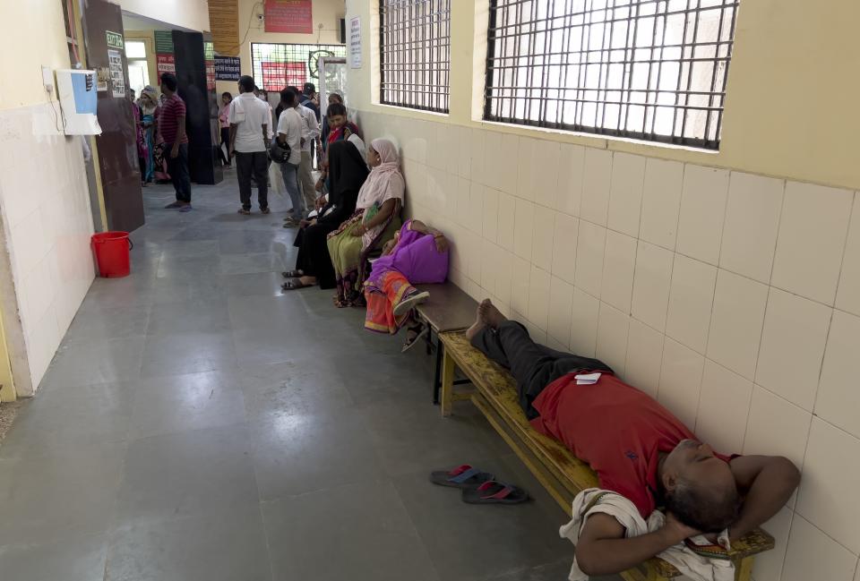 FILE - People wait to consult doctors at Tej Bahadur Sapru Hospital in Prayagraj, Uttar Pradesh state, India, Thursday, June 23, 2022. At least 34 people have died in the past two days as a large swath of the north Indian state of Uttar Pradesh swelters under severe heat, officials said Saturday, prompting doctors to advise citizens above 60 years of age against venturing out during the daytime. (AP Photo/Rajesh Kumar Singh, File)