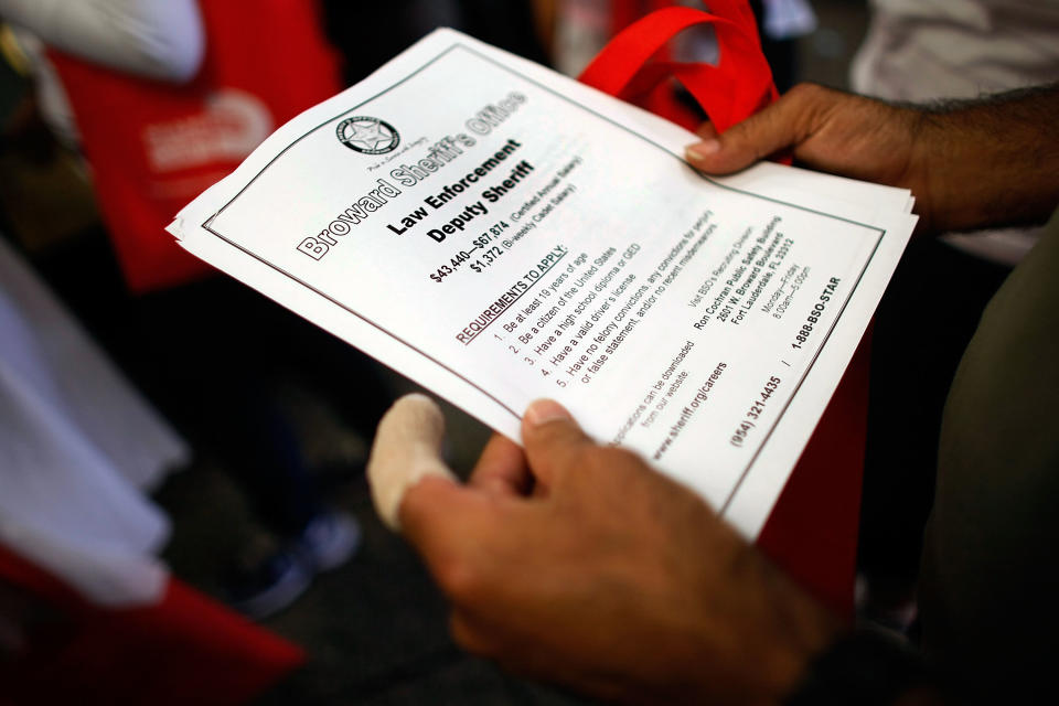 MIAMI - MAY 14:  A person looking for work holds a flyer for a job at the Broward Sheriffs office as they attend the Miami-Dade Community Action Agency job fair on May 14, 2009 in Miami, Florida. The Labor Department announced that the number of new jobless claims rose to 637,000, from a revised 605,000 the previous week.  (Photo by Joe Raedle/Getty Images)