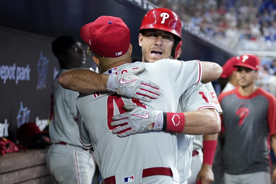 Philadelphia Phillies' J.T. Realmuto, right, hugs Yairo Munoz after hitting a two-run home run during the fourth inning of a baseball game against the Miami Marlins, Saturday, July 16, 2022, in Miami. (AP Photo/Lynne Sladky)