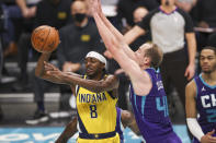 Indiana Pacers guard Justin Holiday (8) passes the ball while Charlotte Hornets center Cody Zeller (40) defends during the first half of an NBA basketball game in Charlotte, N.C., Wednesday, Jan. 27, 2021. (AP Photo/Nell Redmond)