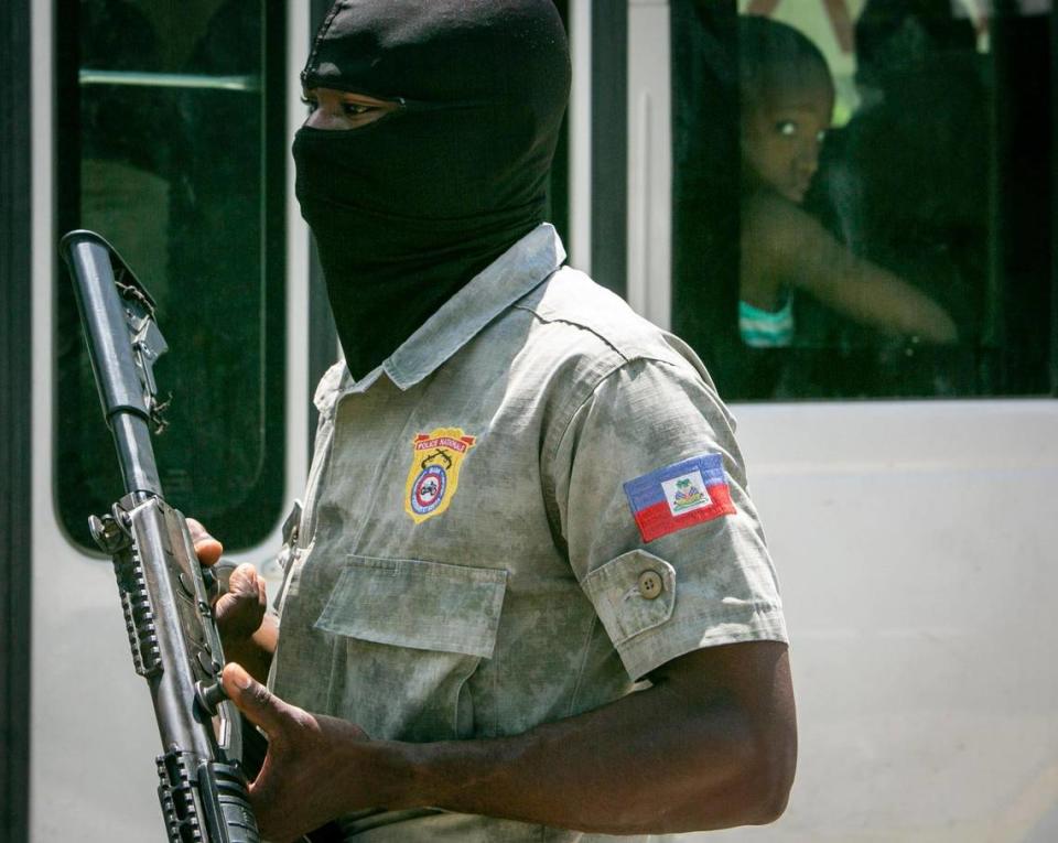 A Haiti National Police officer officer looks out over traffic at a police checkpoint on June 23, 2022 in Tabarre, where recent gang flare ups have sent panic through the population. Haitian police say they lack the proper equipment to combat gangs.