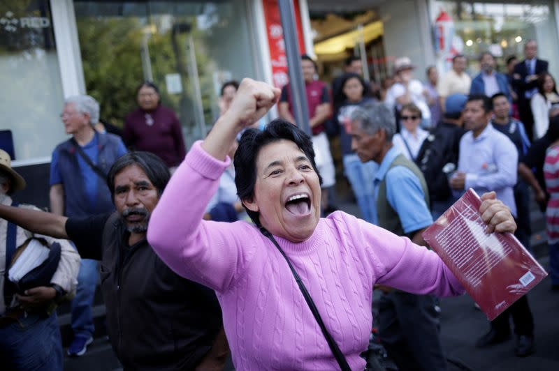 A supporter of Mexican President Andres Manuel Lopez Obrador yells to opposition supporters (not pictured) after a march to protest against violence on the first anniversary of President Andres Manuel Lopez Obrador taking office