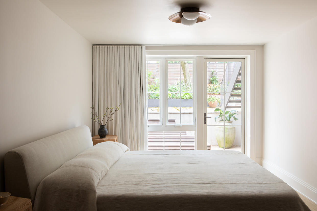  A small bedroom with a large bed and a small nightstand. 