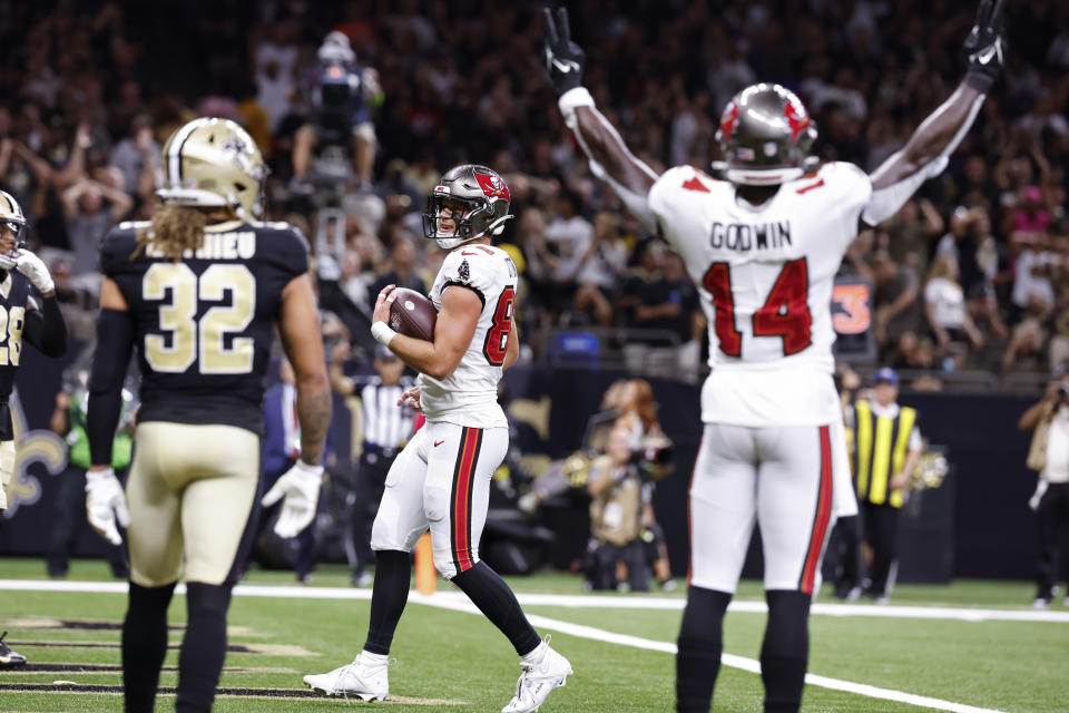 Tampa Bay Buccaneers tight end Cade Otton, center, runs into the end zone for a touchdown, as Tampa Bay Buccaneers wide receiver Chris Godwin (14) celebrates, in the first half of an NFL football game against the New Orleans Saints, in New Orleans, Sunday, Oct. 1, 2023. (AP Photo/Butch Dill)