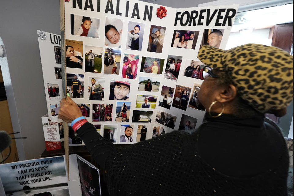 Bernice Ringo looks through photographs of her son Natalian, Tuesday, March 28, 2023, in Detroit. Ringo had hoped to move him away from the crime she had feared most of his life, but those plans crumbled when Natalian was fatally shot in 2019. The victim compensation program ultimately denied Ringo's application because they said her son had contributed to his murder. (AP Photo/Carlos Osorio)