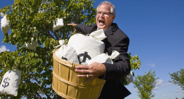 businessman harvesting money from a money tree