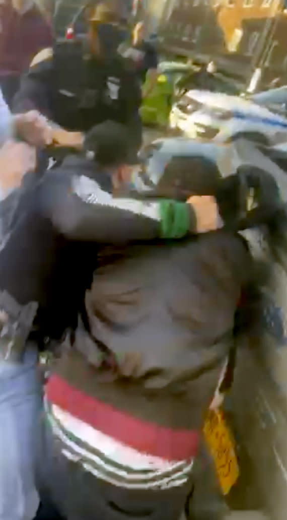 In this April 29, 2020 image made from video provided by Adegoke Atunbi, a New York City Police Officer in plain clothes wrestles a man to the ground while making an arrest in the Brooklyn borough of New York. The video is among those posted on social media recently that show the NYPD using physical force while out enforcing the city's 6-foot-of-distance social distance rule. Despite mounting pressure from watchdogs to stop using police to enforce social distancing, Mayor Bill de Blasio stood by the practice on Thursday, saying: “We’re not going to sideline the NYPD." (Adegoke Atunbi via AP)