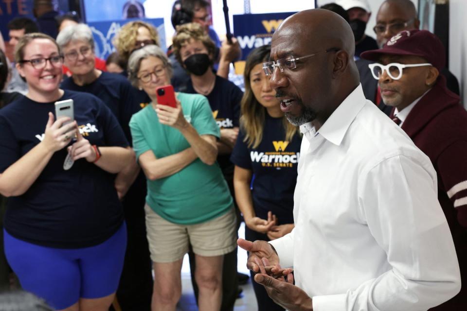 Raphael Warnock spricht mit Unterstützern, während Filmregisseur Spike Lee während einer Werbeveranstaltung am 6. November in Savannah, Georgia (Getty Images) zuhört.