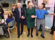 <p>Camilla accessorized her dark green dress suit with a brooch and printed scarf for her visit to the Jewish Care's Brenner Center in Stepney, East London. </p>