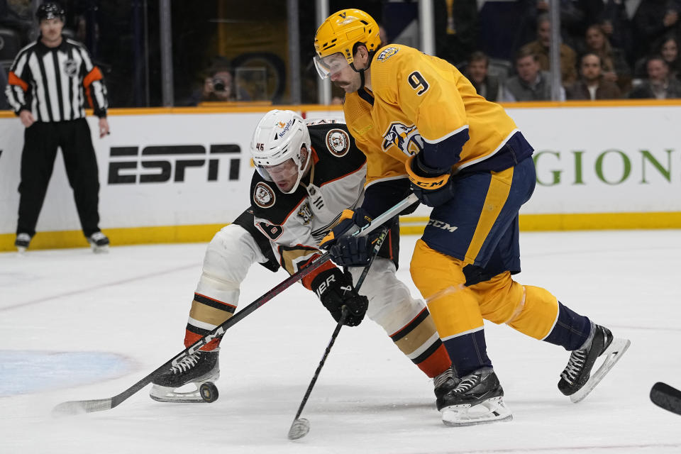 Anaheim Ducks defenseman Ilya Lyubushkin, left, and Nashville Predators left wing Filip Forsberg (9) battle for the puck during the second period of an NHL hockey game Tuesday, Nov. 14, 2023, in Nashville, Tenn. (AP Photo/George Walker IV)