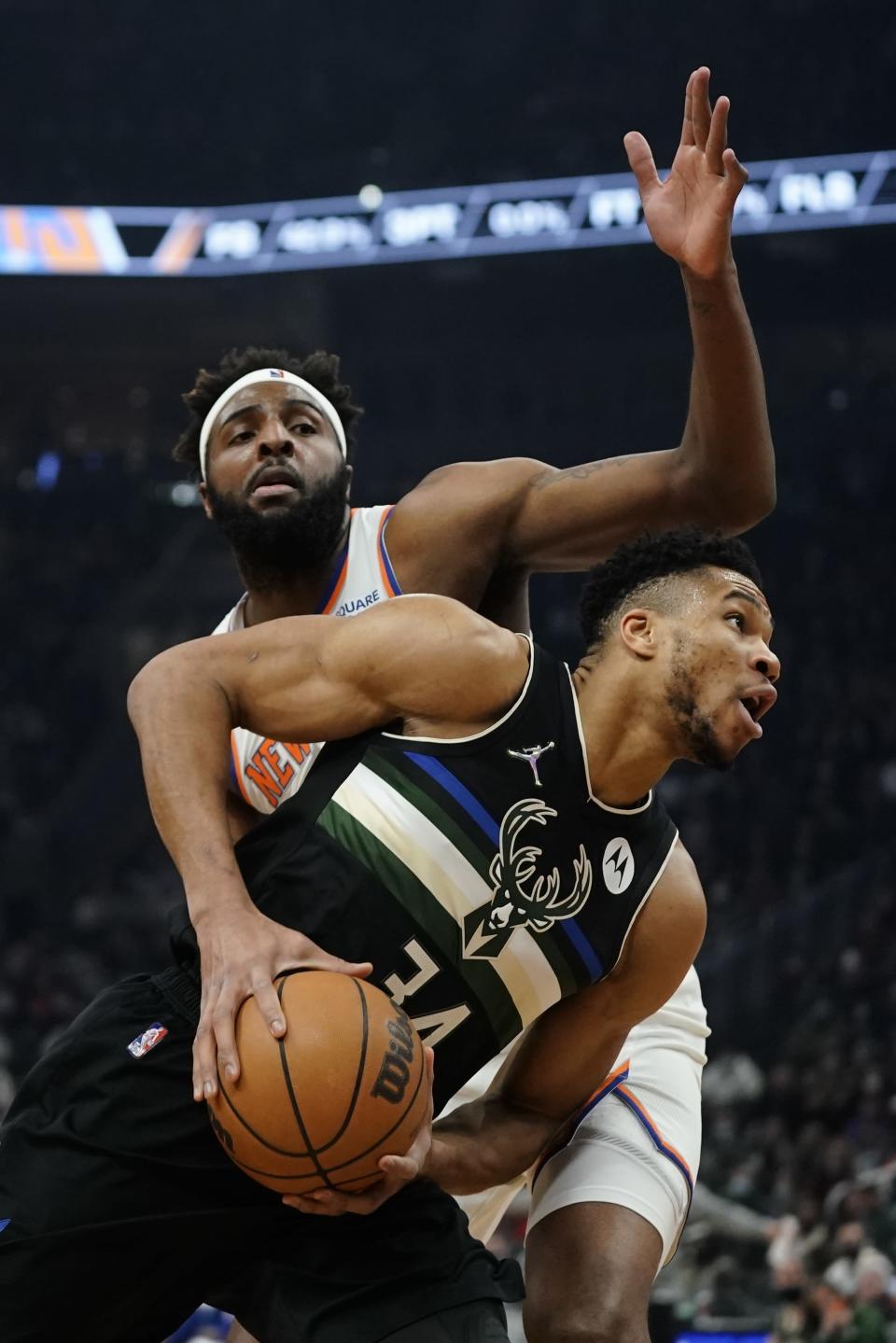 Milwaukee Bucks' Giannis Antetokounmpo is fouled by New York Knicks' Mitchell Robinson during the first half of an NBA basketball game Friday, Jan. 28, 2022, in Milwaukee. (AP Photo/Morry Gash)