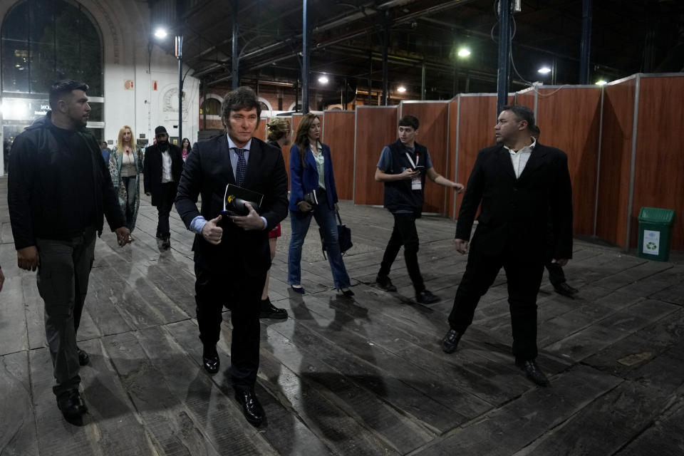 Argentina presidential candidate Javier Milei, second left, arrives to sign books for his supporters titled "The End of Inflation" at the Buenos Aires book fair in Buenos Aires, Argentina, Sunday, May 14, 2023. (AP Photo/Natacha Pisarenko)