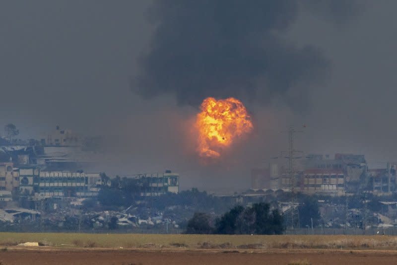 A fires burns after an Israeli military strike inside the Gaza Strip as an Israeli flare falls nearby on Thursday. The United States is asking Israel to be more accurate in its attacks against the terrorist Hamas in the current war which is in its third month. Photo by Jim Hollander/UPI