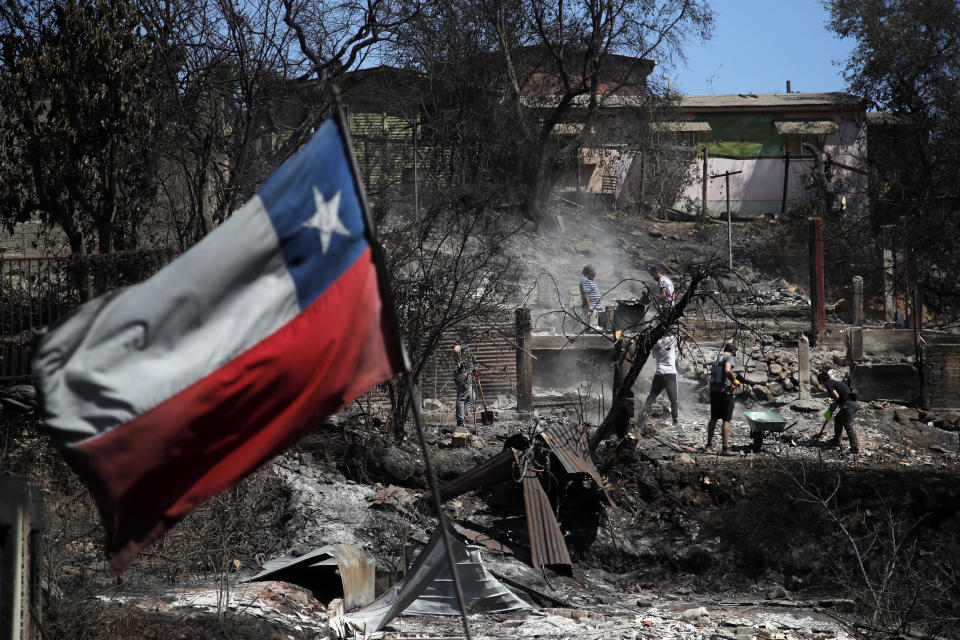 Una bandera de Chile ondea con los incendios como telón de fondo. (Photo by JAVIER TORRES/AFP via Getty Images)