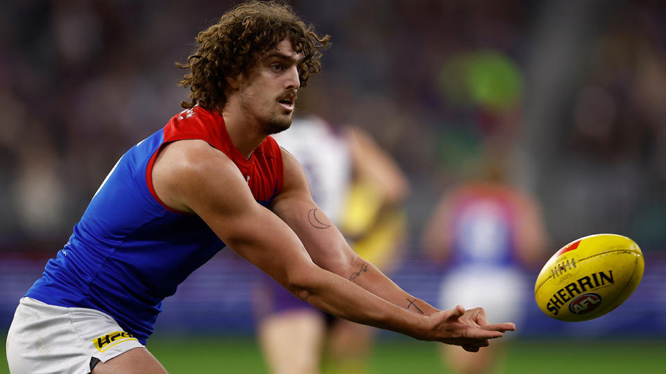 Luke Jackson passes to a teammate during an AFL game.