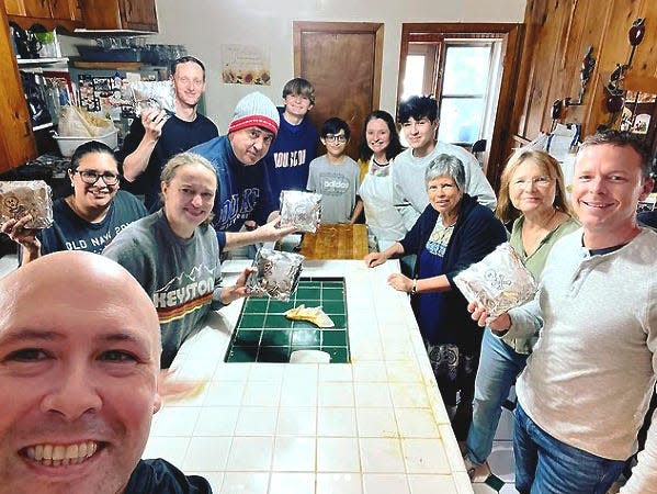 A dozen people gather around a kitchen table making tamales including Albert Alonzo, then a case manager for the Southern District of Texas bankruptcy court, Judge David Jones in the gray cap and his former clerk — and secret romantic partner — Elizabeth Freeman in a green T-shirt.