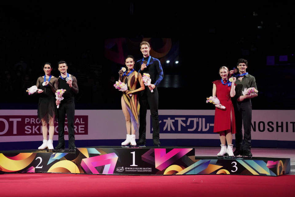 Madison Chock and Evan Bates of the U.S., center, with gold medals, Charlene Guignard and Marco Fabbri of Italy, left, with silver medals, and Piper Gilles and Paul Poirier of Canada, with bronze medals, stand on the podium and pose for a photo during the award ceremony for the ice dance free dance in the World Figure Skating Championships in Saitama, north of Tokyo, Saturday, March 25, 2023. (AP Photo/Hiro Komae)