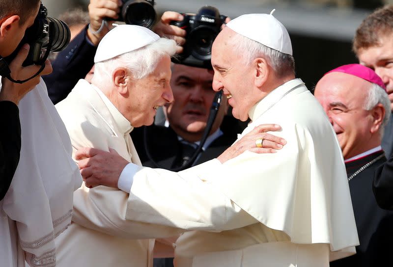 FILE PHOTO: Pope Francis greets Emeritus Pope Benedict XVI before a mass in Saint Peter's square at the Vatican
