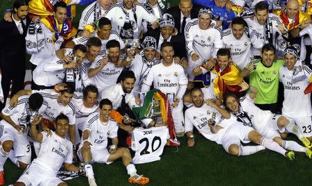 Real Madrid players celebrate with the trophy after winning the King's Cup final soccer match against Barcelona at Mestalla stadium in Valencia April 16, 2014. REUTERS/Heino Kalis