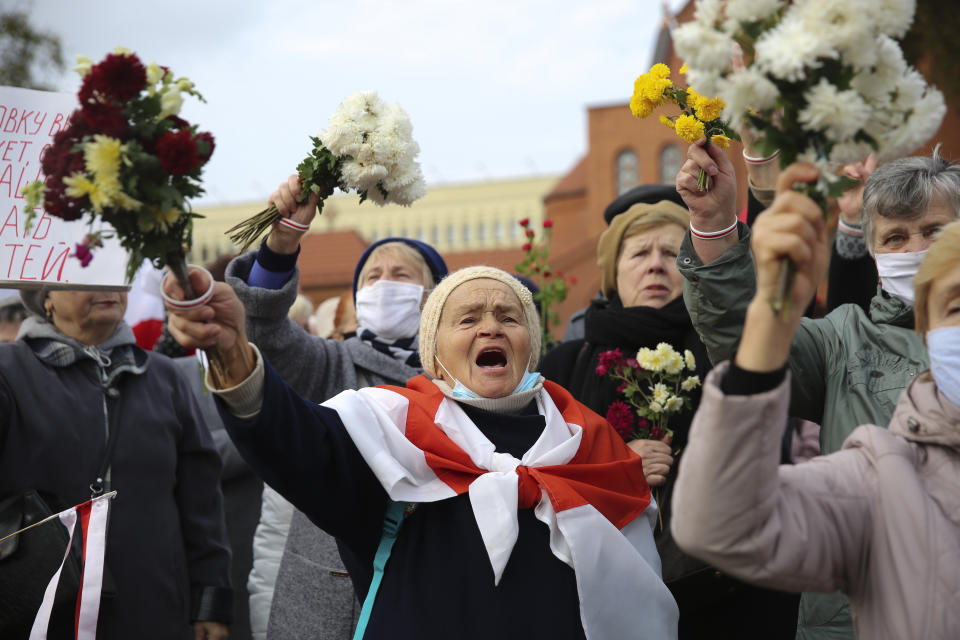 People, most of them pensioners, wave bunches of flowers during an opposition rally to protest the official presidential election results in Minsk, Belarus, Monday, Oct. 26, 2020. Factory workers, students and business owners in Belarus have started a general strike, calling for authoritarian President Alexander Lukashenko to resign after more than two months of mass protests triggered by a disputed election. (AP Photo)