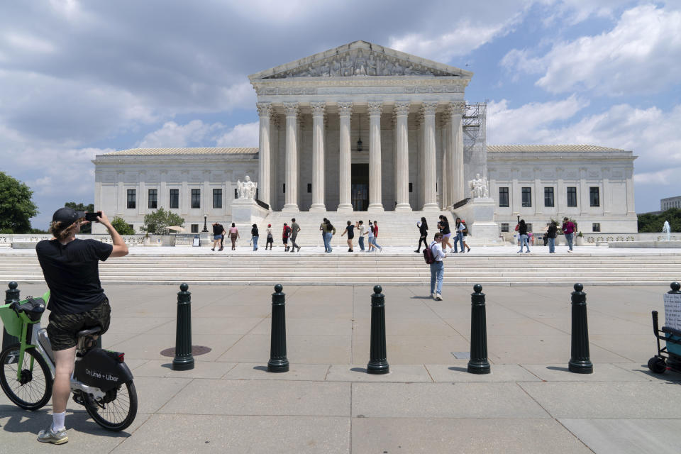 Visitors pose for photographs at the U.S. Supreme Court Tuesday, June 18, 2024, in Washington. ( AP Photo/Jose Luis Magana)