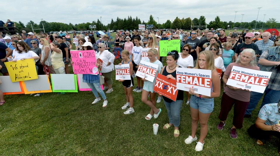 Supporters hold up signs during a protest rally at Rotary Park Thursday, July 13, 2023.