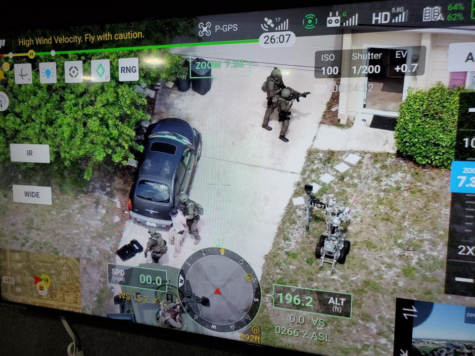 An aerial image shows Volusia sheriff's officers taking a man into custody following a standoff in a residential area near Port Orange on Thursday, May 26.